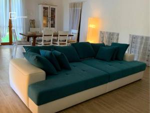 - un canapé vert dans le salon dans l'établissement BellaVista Ivonne - Belocations, à Torre delle Stelle