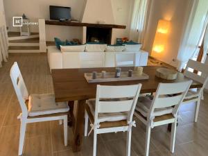 - un salon avec une table, des chaises et un canapé dans l'établissement BellaVista Ivonne - Belocations, à Torre delle Stelle