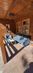 uma sala de estar com cadeiras azuis e uma mesa em Brvnara Morava em Ovcar Banja