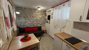 a kitchen and a living room with a couch and a table at Apartment Kova in Split