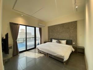 um quarto com uma cama e uma grande janela em Life Inn No 3 em Magong