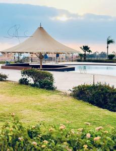 un grande ombrellone abbronzante seduto accanto alla piscina di Porto Sokhna Water Front Resort a Ain Sokhna