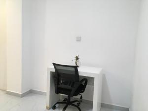 a black chair sitting in front of a white desk at Lavinia Bay Beach Hotel in Mount Lavinia