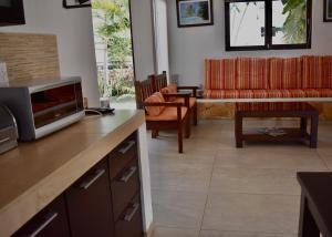 eine Küche und ein Wohnzimmer mit einem TV und einem Sofa in der Unterkunft Casa Kiin in Chichimilá