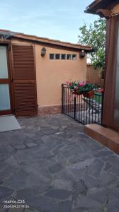 Un cancello per una casa con dei fiori sopra di Suite Felix a Fiumicino