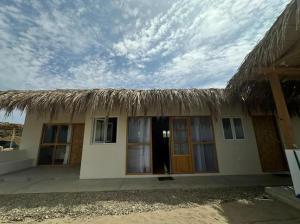 uma pequena casa com um telhado de palha em cima em Vichayito, Órganos, Casa Serendipity em Vichayito