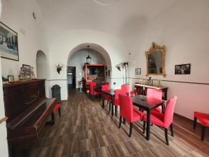 a dining room with red chairs and tables at La Pennichella Sorrentina Relais in Meta
