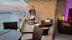 a balcony with chairs and a table and a fan at Amplio 140m2 Grand Diamond Tonsupa in Tonsupa