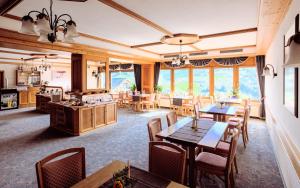 Hotel Schauinsland في باد بيترستال غريسب: غرفة طعام مع طاولات وكراسي ونوافذ