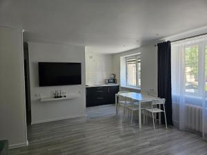 a living room with a table and a television on the wall at Central Space in Daugavpils
