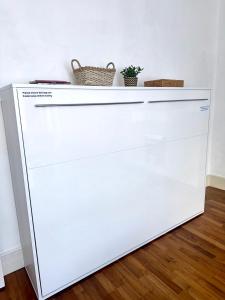 a white dishwasher in a room with two baskets on top at Spacious Belsize Park apartment close to station in London