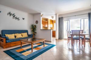 a living room with a blue couch and a table at Close to beach Alvor 1 bedroom apartment Villa da Praia AT08 in Alvor
