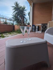 Dos copas de vino sobre una mesa en Lele House Fiumicino - Intero Appartamento Aeroporto di Fiumicino - Nuova Fiera di Roma, en Fiumicino