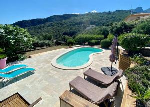 a swimming pool with two chairs and an umbrella at Bella Vita Brando in Brando