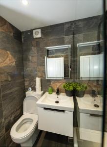 a bathroom with a toilet and a sink and mirror at Royal Retreat & Lego Lodge in London