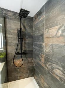 uma casa de banho com um chuveiro e uma parede de pedra em Royal Retreat & Lego Lodge em Londres