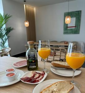 uma mesa com dois copos de sumo de laranja e torradas em Hotel Infanta Leonor em Écija