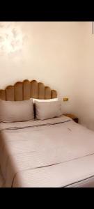 a bedroom with a bed with white sheets and pillows at Hay Mohammadi agadir in Agadir +5 photos