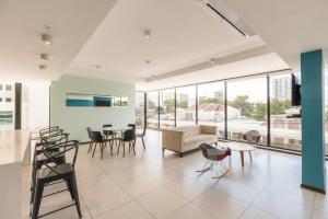 uma sala de estar com um sofá, mesas e cadeiras em Escape to this Rooftop Jacuzzi Apartment em Vuelta del Virilla