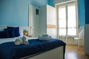 een blauwe slaapkamer met een bed met handdoeken erop bij B&B LIBRA rooms & suite in Salerno