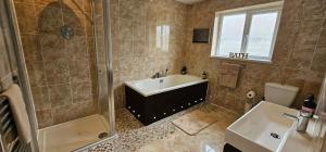 サウス・ヘイリングにあるSeabreeze bungalow a 2 min walk from the beachのシャワー、浴槽、洗面台を備えたバスルーム +11枚の写真