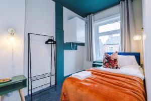 um pequeno quarto com uma cama e uma janela em Charming 3-Bedroom House-Salford em Manchester