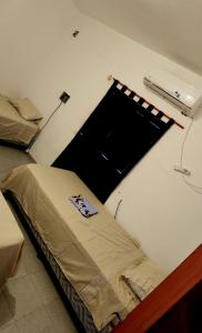 um quarto com uma cama num quarto com uma janela em Apart Hotel - Eucaliptal em Corrientes
