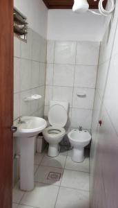 Baño blanco con aseo y lavamanos en Apart Hotel - Eucaliptal en Corrientes