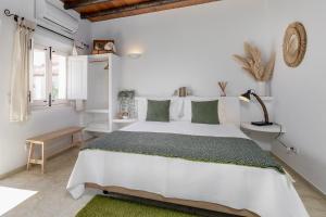 1 dormitorio blanco con 1 cama blanca grande con almohadas verdes en Santa Paciência Reguengos de Monsaraz, en Reguengos de Monsaraz