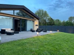 a patio with couches and lights in the grass at Luxuriöse Villa am Wiesensee in Pottum