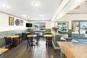 un restaurante con mesas y sillas y un bar en GuestHouse Inn & Suites Kelso/Longview, en Kelso