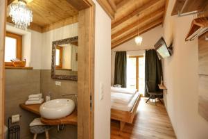 ein Bad mit einem Waschbecken und ein Bett in einem Zimmer in der Unterkunft Landhaus Wiesner - Gästezimmer - Bad - Bett - Kleine Kaffee - Tee-Theke mit Kühlschrank - Parkplatz in Rottach-Egern