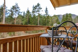 a table on a deck with a view of the woods at Landhaus Wiesner - Gästezimmer - Bad - Bett - Kleine Kaffee - Tee-Theke mit Kühlschrank - Parkplatz in Rottach-Egern