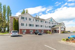 un hotel con coches estacionados en un estacionamiento en GuestHouse Inn & Suites Kelso/Longview, en Kelso