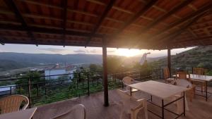 una mesa y sillas en un balcón con vistas a la puesta de sol en Guest House Xhaferaj en Berat