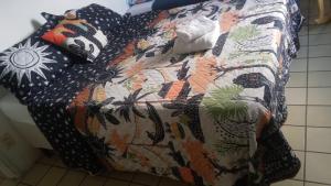 a bed with a comforter and pillows on it at SUITE e QUARTOS -1 SUITE COM BANHEIRO PRIVATIVO - 2 QUARTOS DUPLOS COM BANHEIRO COMPARTILHADO in Recife