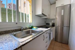 eine Küche mit einer Spüle und einem Kühlschrank aus Edelstahl in der Unterkunft Casa Horta View By MyRentalHost in Barcelona