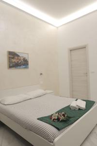 a white bedroom with a bed with flowers on it at Bed & Breakfast Sweet life La spezia Liguria in La Spezia
