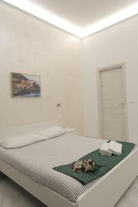 a white bedroom with a bed with flowers on it at Sweet life La spezia Liguria in La Spezia