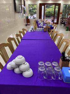a long table with purple table cloth and glasses on it at Thành Đạt Hotel in Cửa Lô