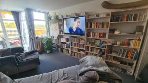 a living room with a tv and book shelves at Ferienwohnung am Müritzstrand in Waren