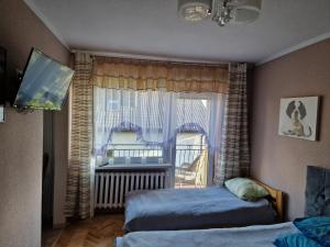 1 dormitorio con 2 camas y ventana en AGNES, en Grzybowo