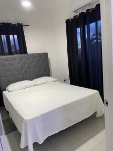 a bedroom with a large bed with black curtains at Residencial Sosua 1-2 in Sosúa