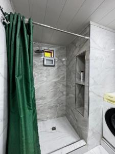 a shower with a green shower curtain in a bathroom at Vintage Boutique Hostel in Baku +51 photos