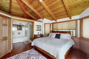 Horizon's End في Islandale: غرفة نوم بسرير في غرفة بسقوف خشبية