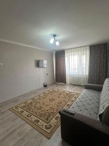 sala de estar con sofá y alfombra en Назарбаева 204, en Pavlodar