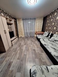Cette grande chambre comprend deux lits et une télévision. dans l'établissement Назарбаева 204, à Pavlodar