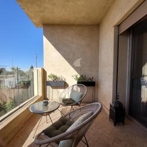 uma varanda com cadeiras, uma mesa e uma janela em Luxury F3 appartment Les Orangers em Marrakech