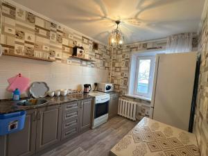 a kitchen with a sink and a refrigerator at Назарбаева 204 in Pavlodar