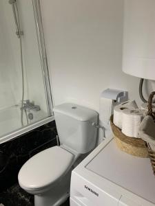 a bathroom with a white toilet and a bath tub at KIFKIF in Saint-Germain-lès-Arpajon